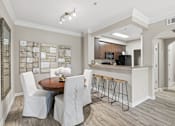 Thumbnail 4 of 29 - A modern kitchen with a dining table and chairs.