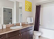 Thumbnail 14 of 29 - A bathroom with a white sink and a white toilet.