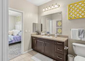 Thumbnail 13 of 29 - A bathroom with a vanity, toilet, and a mirror.