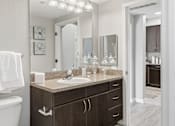 Thumbnail 10 of 29 - A bathroom with a sink, mirror, and toilet.
