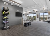 Thumbnail 23 of 41 - room with gym equipment and a television at the district flats apartments at Deca Apartments, Greenville, South Carolina
