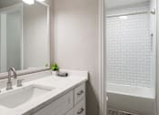 Thumbnail 6 of 20 - A white bathroom with a sink, mirror at Dunwoody Glen, Atlanta
