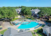 Thumbnail 9 of 22 - A large swimming pool surrounded by trees and houses at Enclave at Wolfchase Apartments, Memphis, 38016