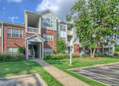 Thumbnail 21 of 22 - Apartment building with a tree in front at Enclave at Wolfchase Apartments, Tennessee 38016