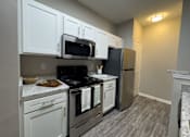 Thumbnail 2 of 22 - A kitchen with white cabinets and a black stove top at Enclave at Wolfchase Apartments, Memphis, TN 38016
