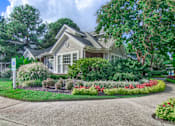 Thumbnail 18 of 22 - A house with a well-maintained garden in front at Enclave at Wolfchase Apartments, Memphis, TN 38016