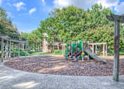 Thumbnail 12 of 22 - A playground with a green slide and a yellow ball at Enclave at Wolfchase Apartments, Memphis, TN