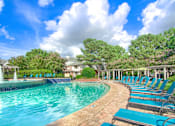 Thumbnail 10 of 22 - A pool surrounded by trees and chairs at Enclave at Wolfchase Apartments, Tennessee