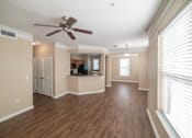 Thumbnail 5 of 16 - A room with a ceiling fan and wooden floors.