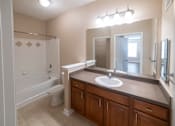 Thumbnail 6 of 16 - A bathroom with a white toilet and a white sink.