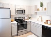 Thumbnail 19 of 30 - a kitchen with white cabinets and stainless steel appliances at Appling Lakes, Cordova, TN, 38016