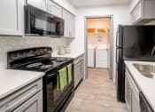 Thumbnail 2 of 19 - a kitchen with white cabinets and black appliances and a black refrigerator at 1900 Rosemont, Roswell, Georgia