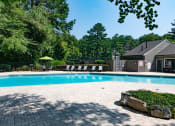 Thumbnail 11 of 19 - a swimming pool with a house and trees in the background