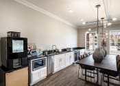 Thumbnail 18 of 30 - a kitchen and dining room with a table and a television at Arlo Luxury homes Apartments, Little Rock, AR