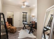 Thumbnail 10 of 30 - a living room with a desk and a mirror at Arlo Luxury homes Apartments, Little Rock, AR