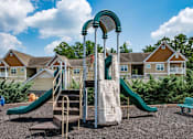 Thumbnail 21 of 28 - a playground with a slide and climbing equipment in front of a row of houses at Ashby at Ross Bridge, Hoover, Alabama