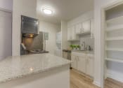 Thumbnail 4 of 21 - a kitchen with granite counter tops and a stainless steel refrigerator at Brightwaters Apartments, Little Rock, Arkansas