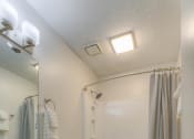 Thumbnail 9 of 21 - a bathroom with a shower and a toilet and a sink at Brightwaters Apartments, Little Rock, AR