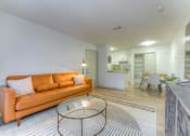 Thumbnail 7 of 21 - a living room with an orange couch and a glass coffee table at Brightwaters Apartments, Little Rock