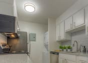 Thumbnail 3 of 21 - a kitchen with white cabinets and stainless steel appliances at Brightwaters Apartments, Little Rock, 72202
