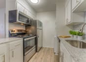 Thumbnail 2 of 21 - a kitchen with white cabinets and stainless steel appliances at Brightwaters Apartments, Little Rock, AR