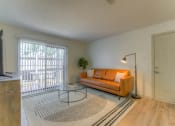 Thumbnail 5 of 21 - a living room with an orange couch and a sliding glass door at Brightwaters Apartments, Little Rock, Arkansas