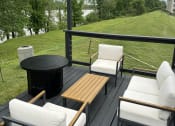 Thumbnail 19 of 21 - a patio with a table and chairs and a fire pit at Brightwaters Apartments, Arkansas