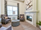 Thumbnail 15 of 31 - A living room with a fireplace and a painting on the wall.