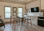 Thumbnail 16 of 31 - A kitchen with a table and chairs in front of a window.