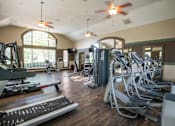 Thumbnail 12 of 31 - A gym with treadmills, elliptical machines, and other exercise equipment.