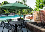 Thumbnail 23 of 31 - A patio with a table, chairs and an umbrella.