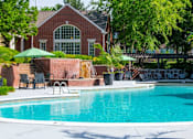 Thumbnail 21 of 31 - A pool in front of a house with a green umbrella.