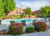 Thumbnail 20 of 31 - A pool surrounded by a garden with a house in the background.