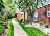 Thumbnail 30 of 31 - A tree in front of a red brick house.