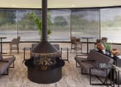 Thumbnail 6 of 14 - a living room with a fireplace in the middle at Esplanade District Apartments, Little Rock