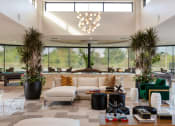 Thumbnail 3 of 14 - the lobby of a hotel with a couch and chairs and large windows at Esplanade District Apartments, Little Rock, AR,72114