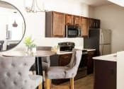 Thumbnail 7 of 14 - a kitchen and dining room with a table and chairs at Esplanade District Apartments, Arkansas