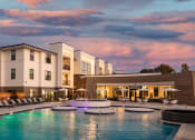Thumbnail 1 of 14 - a large swimming pool in front of a hotel at Esplanade District Apartments, Arkansas