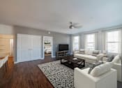 Thumbnail 6 of 21 - A living room with a white couch and a television.