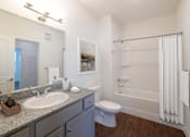 Thumbnail 9 of 21 - A bathroom with a white sink, toilet, and bathtub.