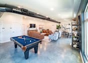 Thumbnail 13 of 21 - A pool table is in the middle of a room with a long black pipe on the ceiling.
