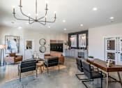 Thumbnail 14 of 21 - A modern living room with a large chandelier and a variety of seating options.