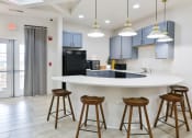 Thumbnail 25 of 34 - a kitchen with a large island with bar stools and blue cabinets at Legends at Chatham Apartments, Savannah