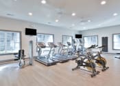 Thumbnail 20 of 34 - a gym with cardio equipment and windows at Legends at Chatham, Savannah, GA