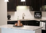 Thumbnail 6 of 34 - a kitchen with a counter top with two stools at Legends at Chatham, Georgia, 31405