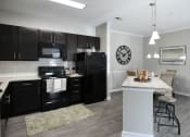 Thumbnail 2 of 34 - a kitchen with black appliances and a marble counter top at Legends at Chatham Apartments, Savannah