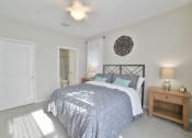 Thumbnail 9 of 34 - a bedroom with a bed and a door to a bathroom at Legends at Chatham Apartments, Savannah
