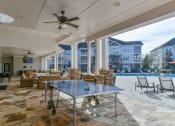 Thumbnail 19 of 34 - a covered poolside patio with a ping pong table at Legends at Chatham, Savannah, GA