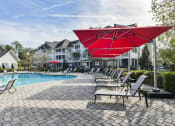 Thumbnail 18 of 34 - our apartments offer a swimming pool with chairs and umbrellas at Legends at Chatham, Georgia, 31405