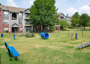 Thumbnail 22 of 24 - a large grassy area with a playground and picnic tables in front of an apartment complex at Lincoln at Wolfchase, Cordova